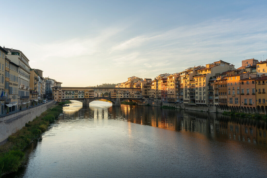 Europe, Italy, Florence: first golden lights behind the famous Ponte Vecchio