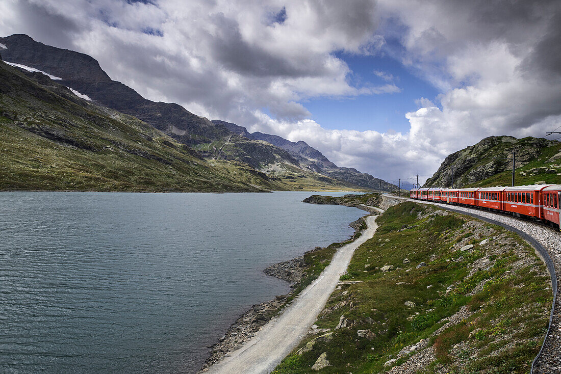 Zug der Bernina während der Fahrt nach St. Moritz, mit weissem und schwarzem See in Ospizio del Bernina Gebiet Ospizio del Bernina, Kanton Grigioni, Schweiz