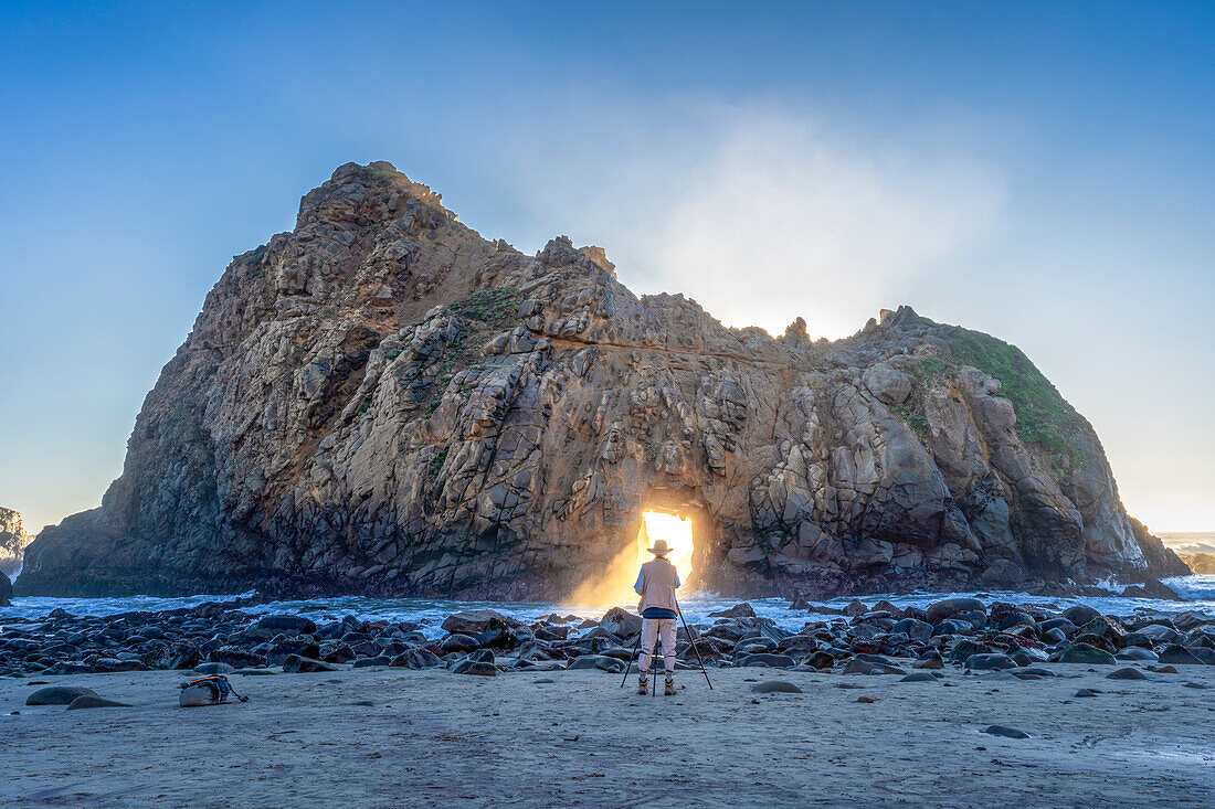 Fotograf vor einem Ack Rock bei Sonnenuntergang, Pfeiffer Beach, Kalifornien, USA