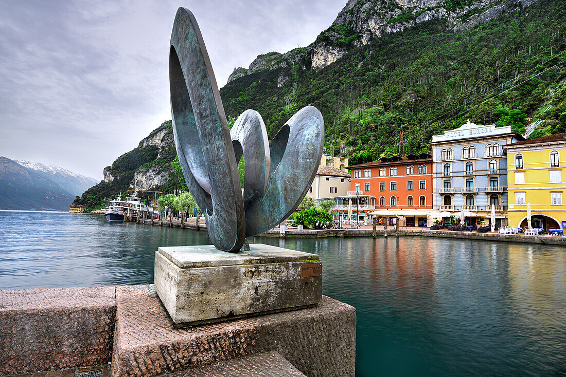 moderne Skulptur im Zentrum von Riva del Garda, mit dem Platz Catena im Hintergrund. Riva del Garda, Gardasee, Trentino-Südtirol, Provinz Trient, Italien, Südeuropa