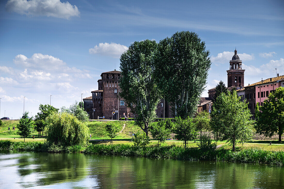 Mincio river with typical vegetation, in background a glimpse of the castle of San Giorgio in the middle of the trees and the bell tower of the Palatine basilica Mantova, Lombardia, north Italy, south Europe