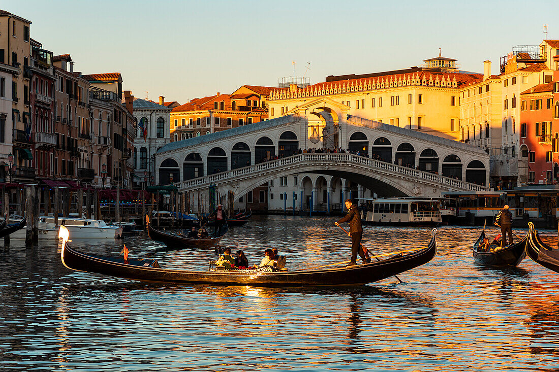 Eine Gondel überquert den Canal Grande. Im Hintergrund die Rialto-Brücke. Venedig, Venetien, Italien, Europa.