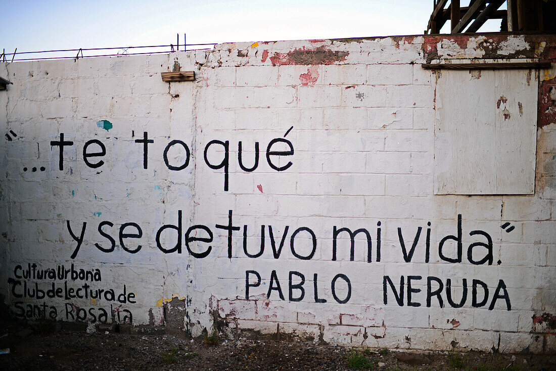 Gedicht von Pablo Neruda an einer Straßenwand: Ich berührte dich und mein Leben blieb stehen. Santa Rosalia, Baja California Sur, Mexiko
