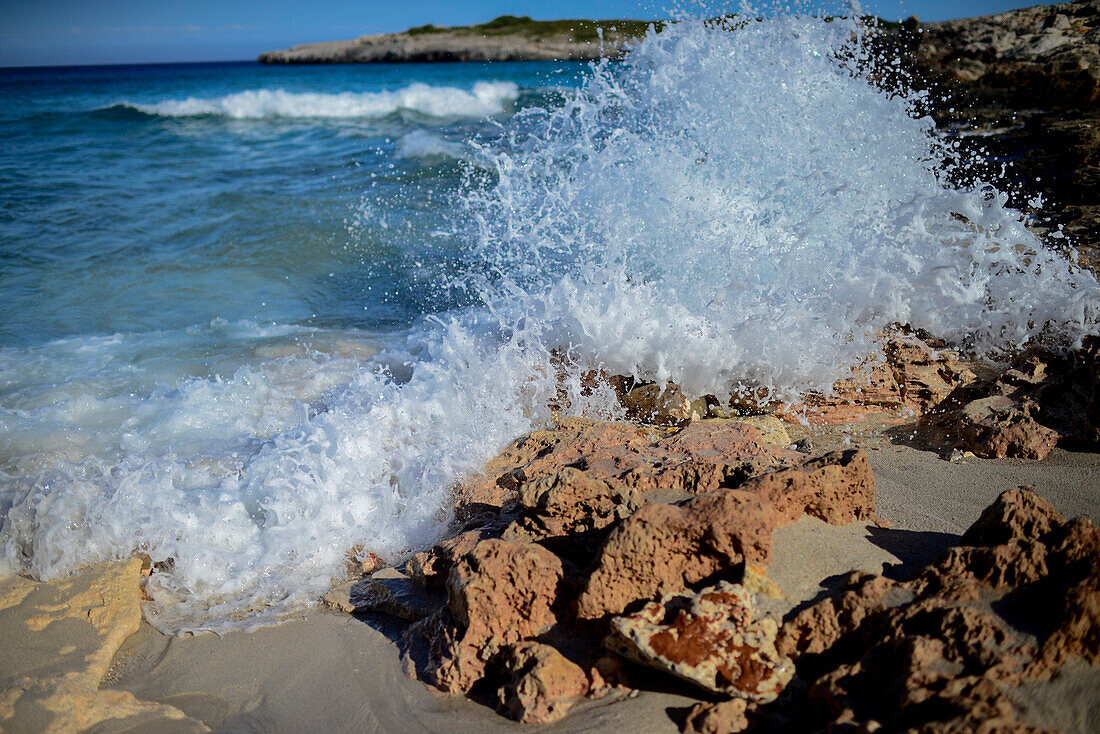 Wellen schlagen gegen die Felsen in Cala Varques auf Mallorca, Spanien