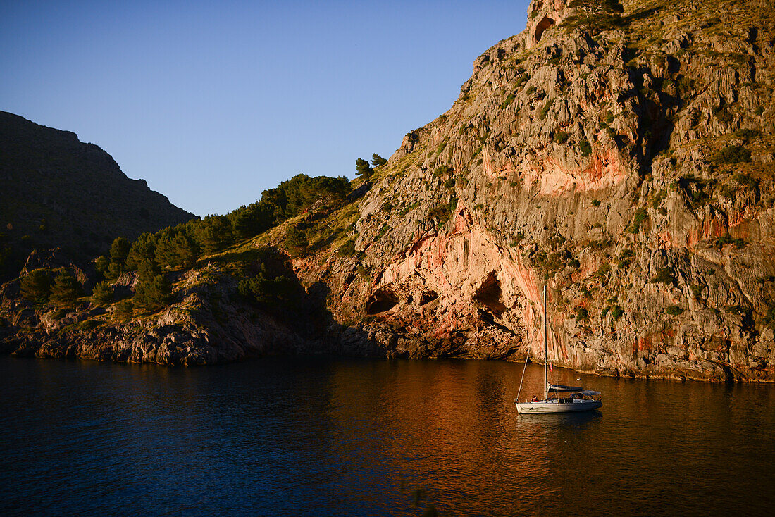 Segelboot bei Sonnenuntergang in Torrent de Pareis, Mallorca, Spanien