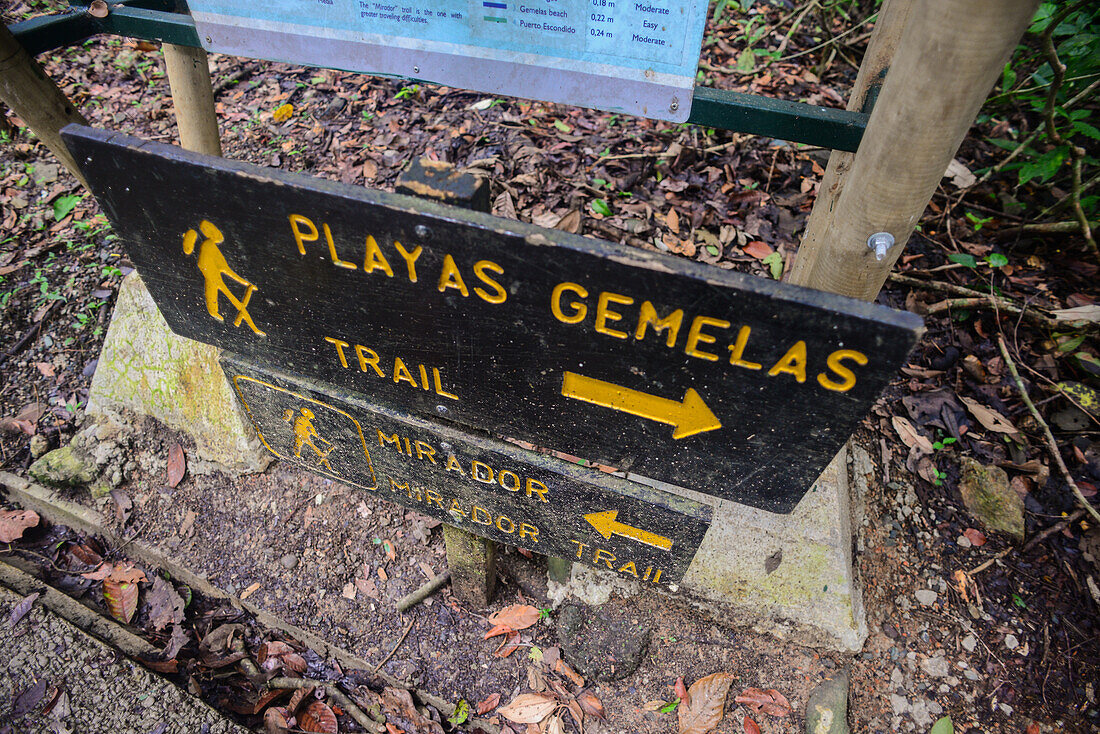 Wooden sign indicates way to the Beach in Manuel Antonio National Park in Costa Rica