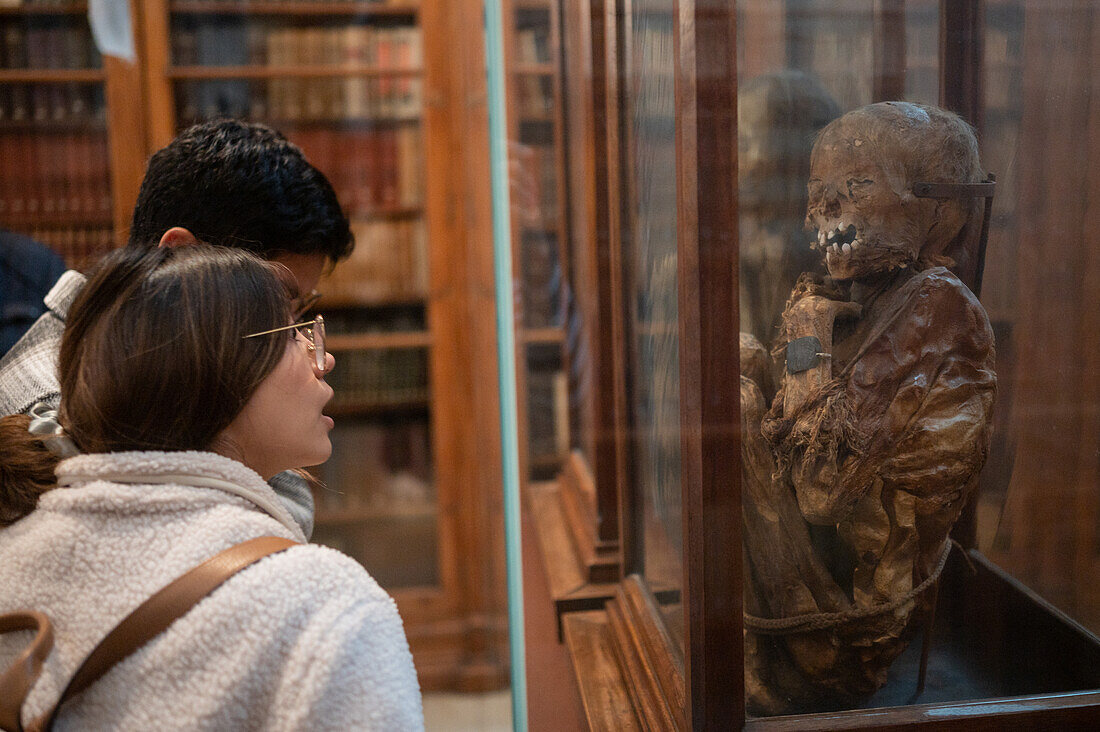Besucher, die mit der Mumie eines Mädchens und eines Jungen im Archäologischen Museum Carmo (MAC) im Kloster Carmo, Lissabon, Portugal, überrascht werden