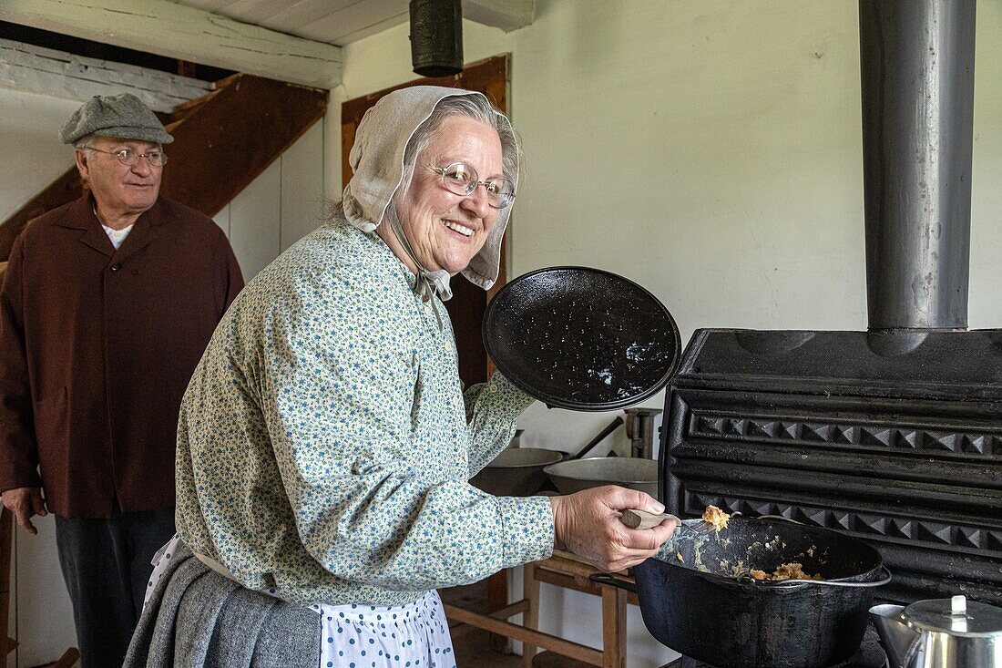 The cook at the stove, leger house built in 1836, historic acadian village, bertrand, new brunswick, canada, north america