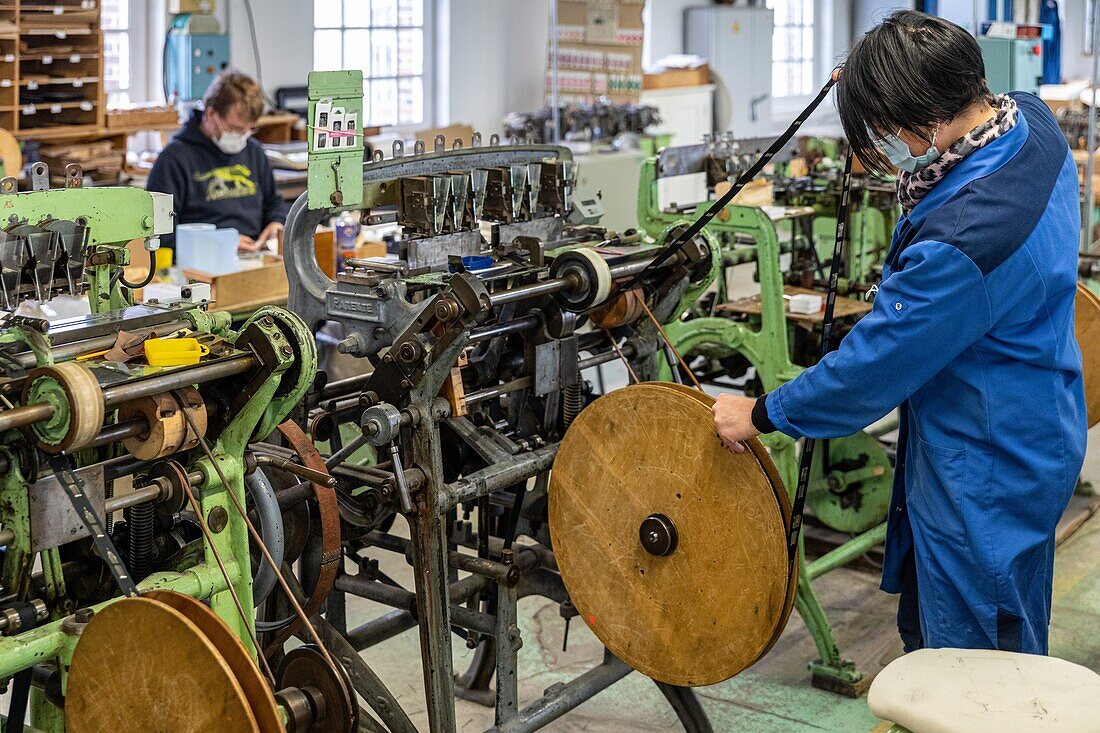 Worker threading needles on the bobbins of fabric before the final packaging, factory of the manufacture bohin, living conservatory of the needle and pin, saint-sulpice-sur-risle, orne (61), france