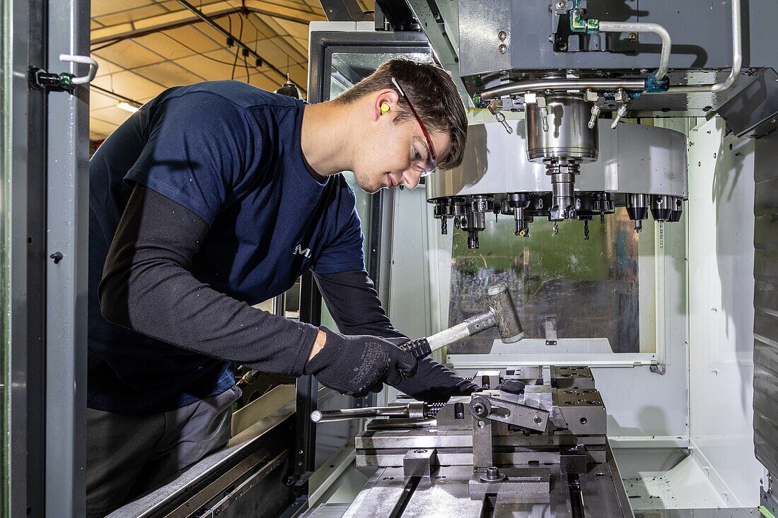 Worker installing a part in his machine, sma, societe mecanique aiglonne, metallurgical industry, saint-martin-d'ecublei, orne, normandy, france