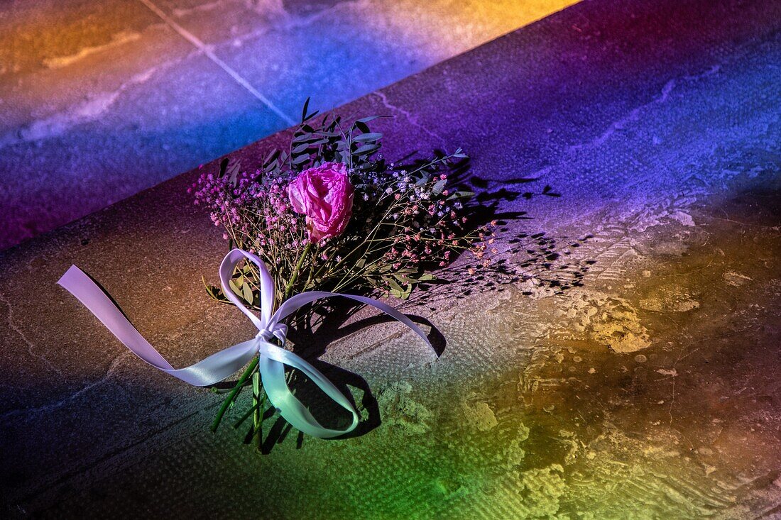 Bride's bouquet in the reflections of the stained glass on the floor and feet, saint-sauveur abbey church, aniane, herault, occitanie, france