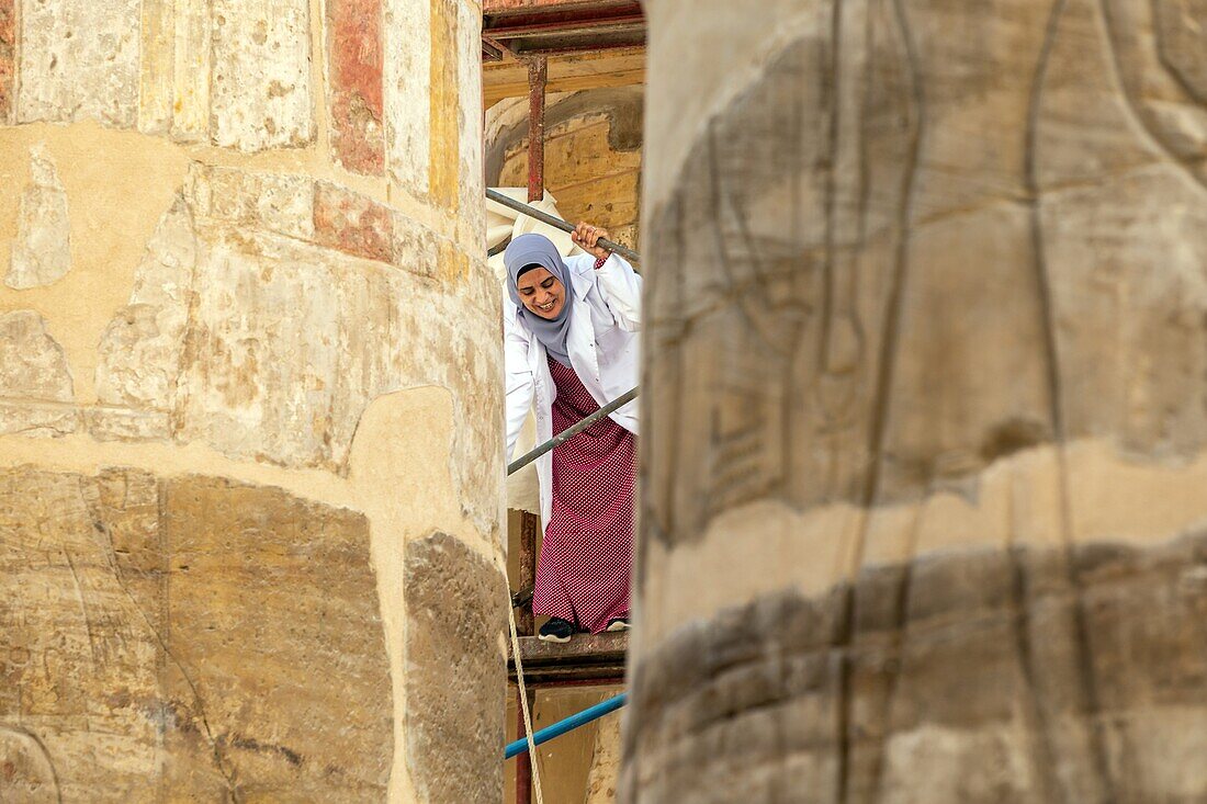 Frau auf dem Gerüst für die Restaurierungsarbeiten an den Säulen der großen Hypostylhalle, Bezirk von Amun-Ré, Tempel von Karnak, antike ägyptische Stätte aus der 13. Dynastie, UNESCO-Welterbe, Luxor, Ägypten, Afrika