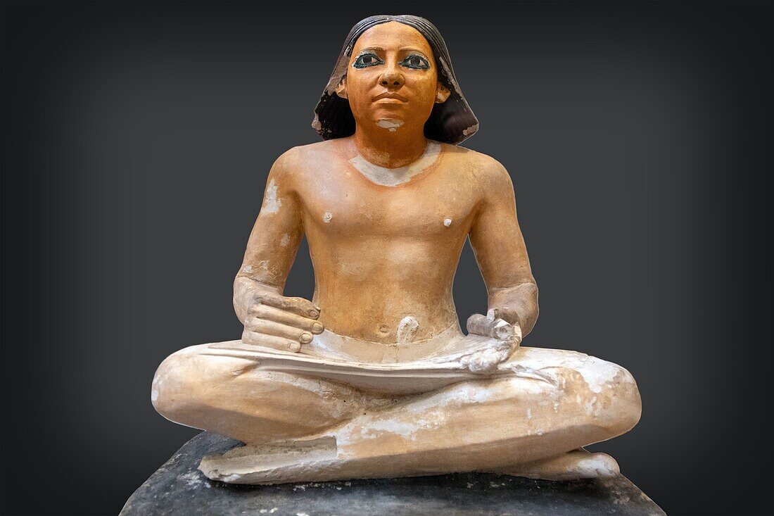 Sitzender Schreiber, bemalte Kalksteinstatue aus der 5. Dynastie, gebildeter Bürokrat des alten Ägyptens, bekannt für die Kunst des Schreibens und Rechnens, Ägyptisches Museum von Kairo, das dem ägyptischen Altertum gewidmet ist, Kairo, Ägypten, Afrika