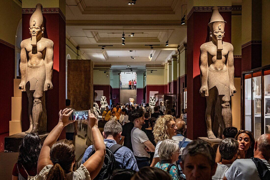 Crowd of tourists in front of the pink granite colossus of king senousert iv (seneferibre), egyptian museum of cairo devoted to egyptian antiquity, cairo, egypt, africa