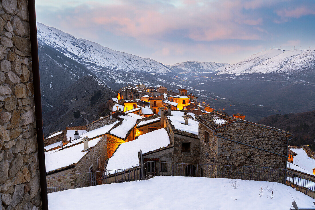 Winterlicher Sonnenuntergang im Bergdorf Castrovalva mit schneebedeckten und verschneiten Bergen im Hintergrund, Provinz L'Aquila, Abruzzen, Italien