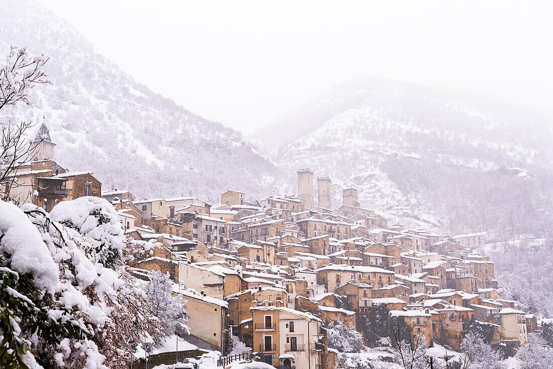 Das mittelalterliche Dorf Pacentro unter starkem Schneefall mit dem Schloss, dem Glockenturm und dem schneebedeckten Haus, Gemeinde Pacentro, Nationalpark Maiella, Provinz L'aquila, Abruzzen, Italien