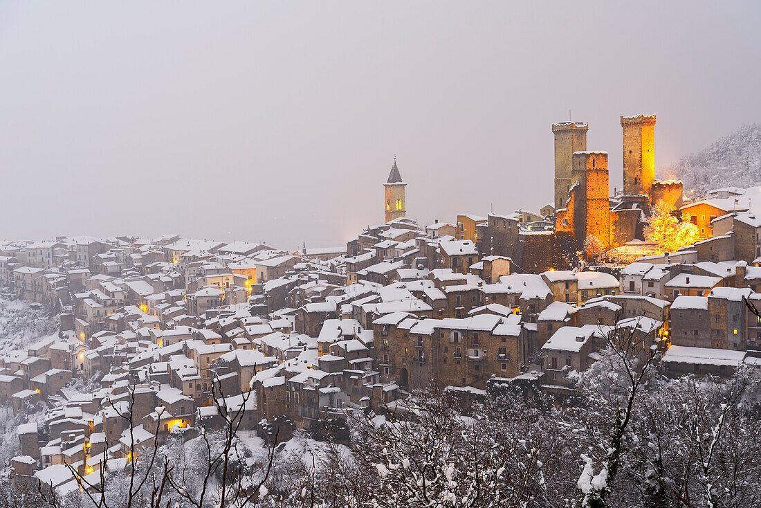 The winter panoramic illuminated medieval village of Pacentro with the castle and bell tower and snow covered house, Pacentro municipality, Maiella national park, L’aquila province, Abruzzo, Italy