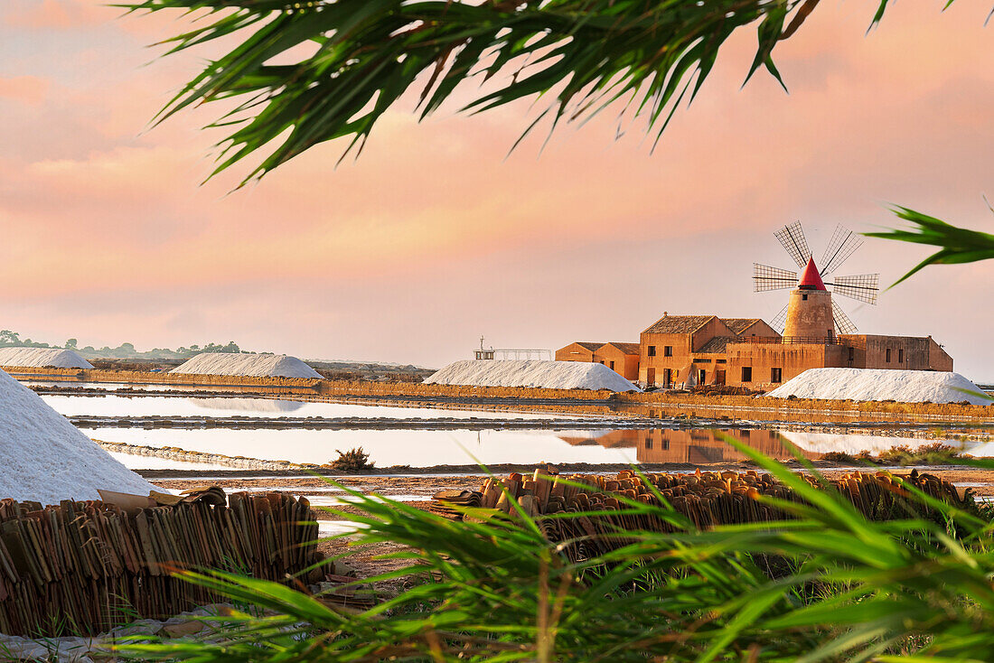 Sunset at the salt flats with the old windmill, saline dello Stagnone, Marsala, Trapani province, Sicily, Italy