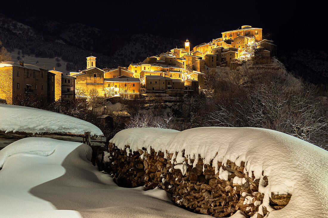Nächtlicher Blick auf das beleuchtete, schneebedeckte Dorf Villalago, Nationalpark Abruzzen, Provinz L'aquila, Abruzzen, Italien
