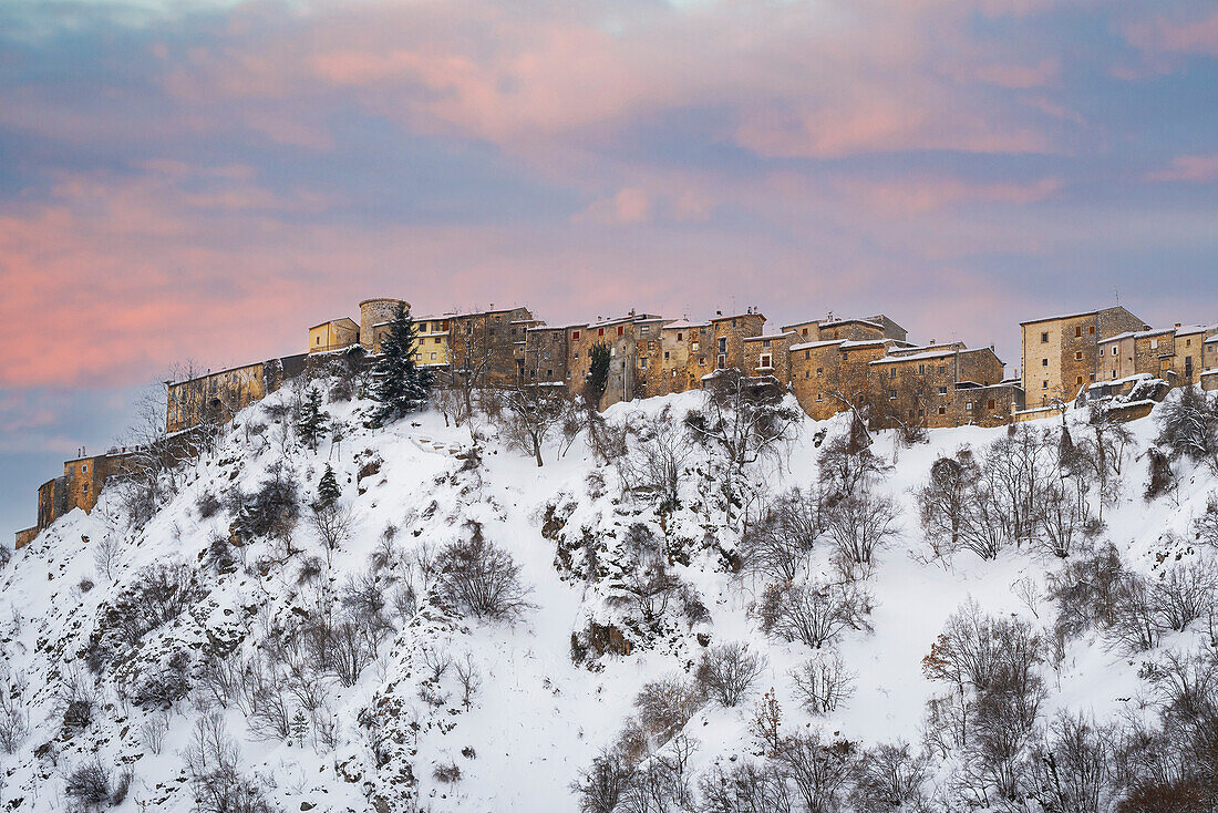 Panoramablick nach Schneefall bei Sonnenuntergang auf das alte Dorf Villalago, Abruzzen-Nationalpark, Provinz L'aquila, Abruzzen, Italien