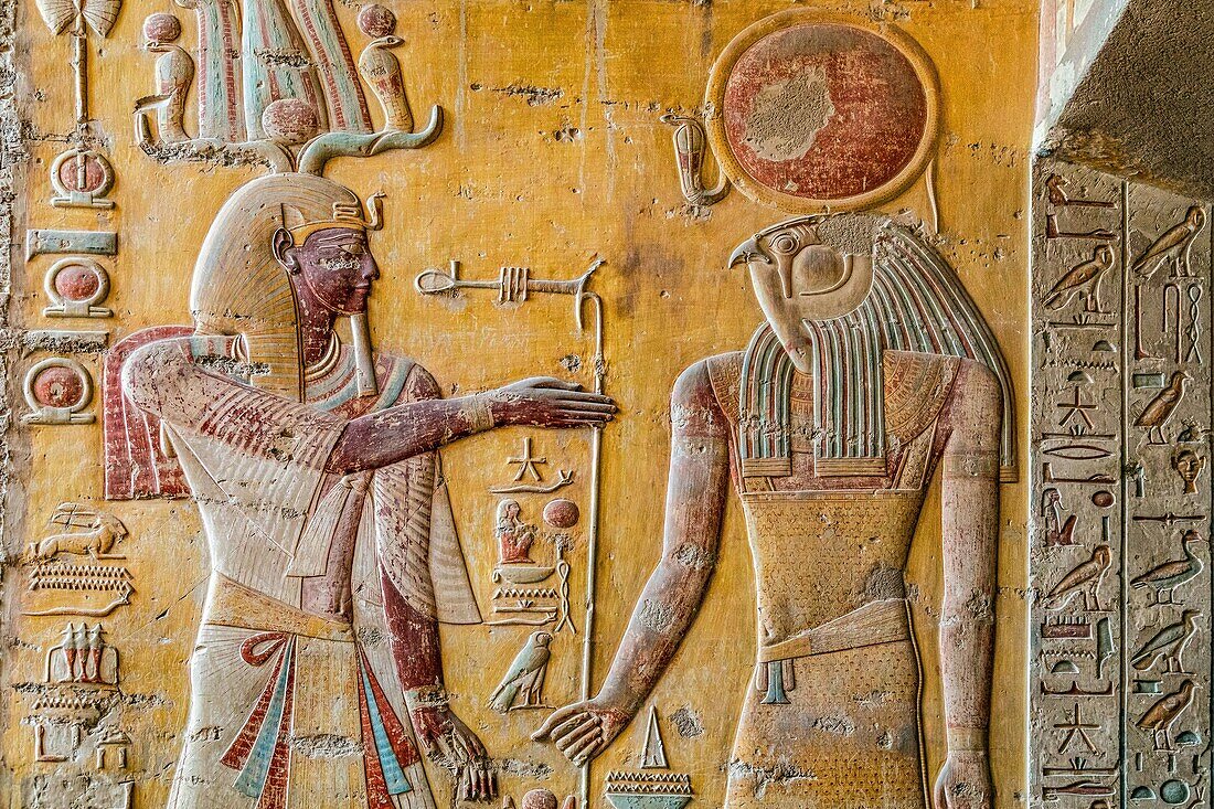 Merenptah im Gespräch mit dem falkenköpfigen Gott Horus, Flachrelief und Fresken in leuchtenden Farben, ägyptische Hieroglyphen, heilige Schriften, Grab des Pharaos Merenptah, Tal der Könige, wo sich das Hypogäum vieler Pharaonen des Neuen Reiches befindet, Luxor, Ägypten, Afrika
