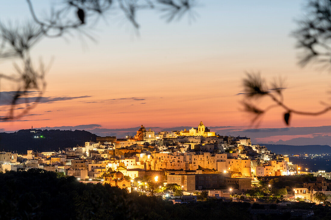 Illuminated houses in the old town of Ostuni at sunset, province of Brindisi, Salento, Apulia, Italy