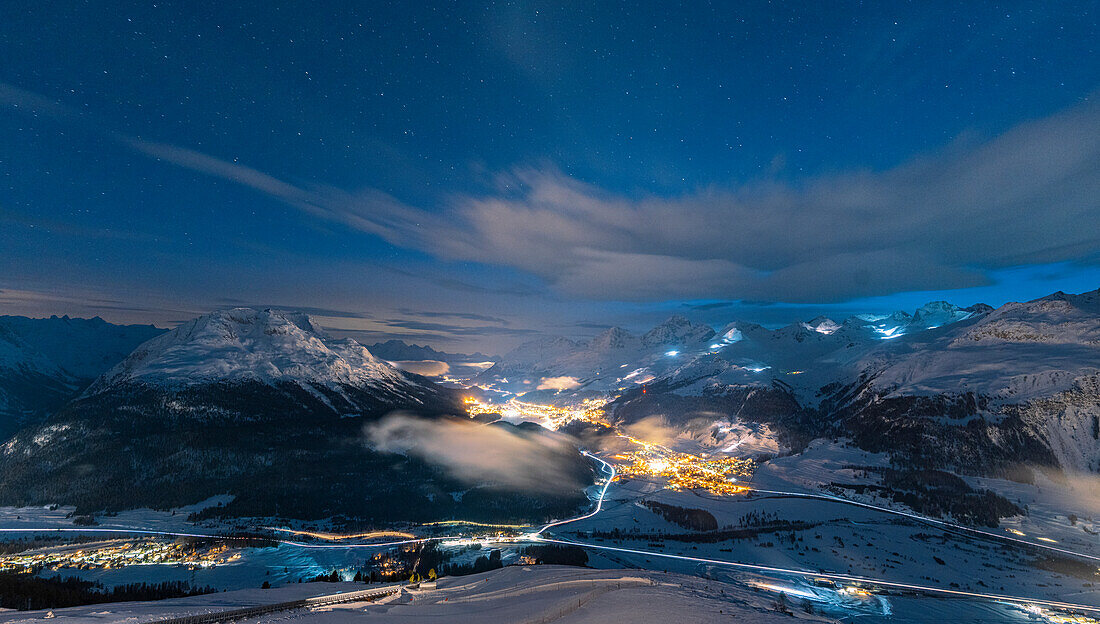 Night view of villages and mountains of Upper Engadin covered with snow from Muottas Muragl, Graubunden canton, Switzerland