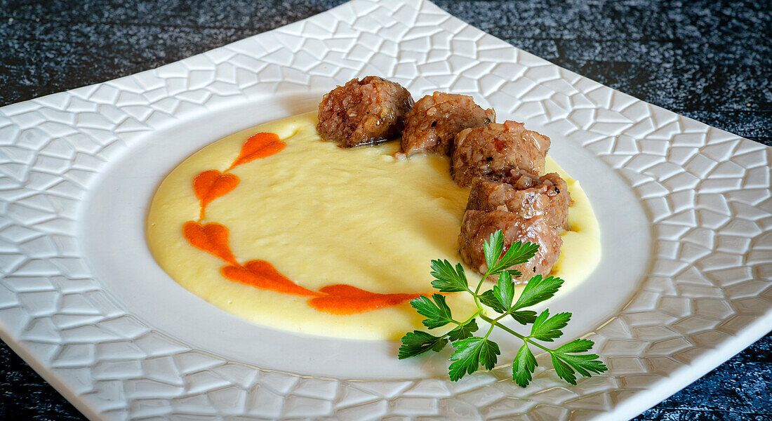 Traditional italian cotechino with potatoes cream soup