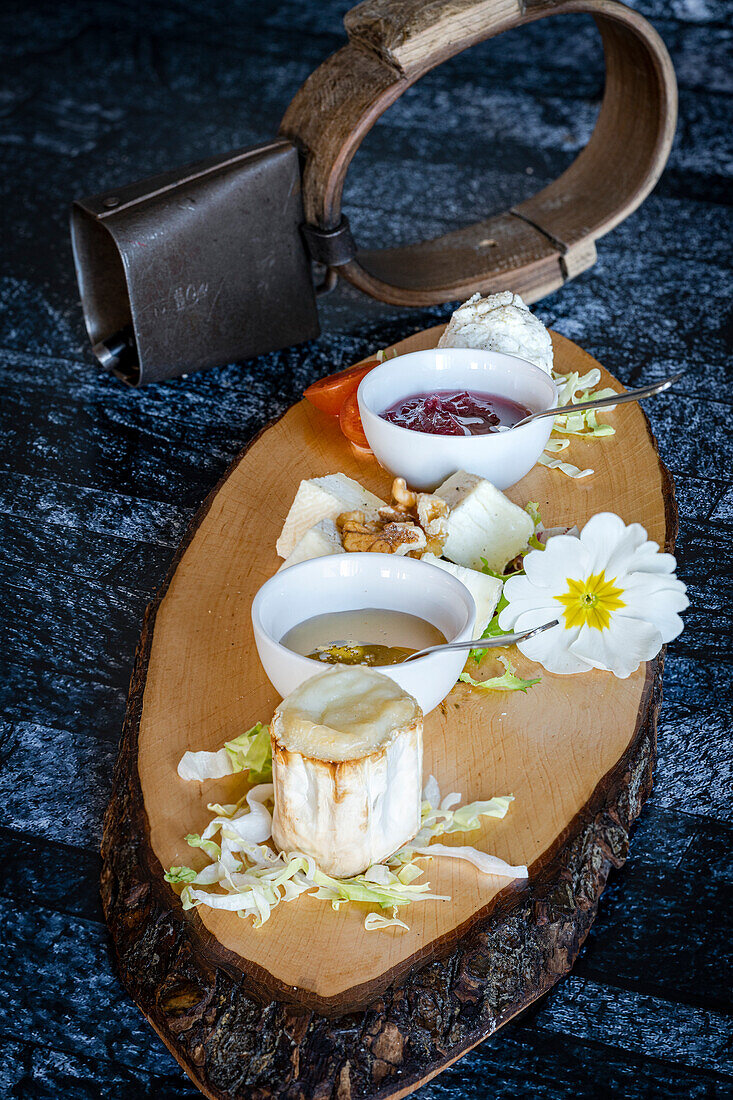 Italian goat cheese served with fruit jam and honey on wood chopping board