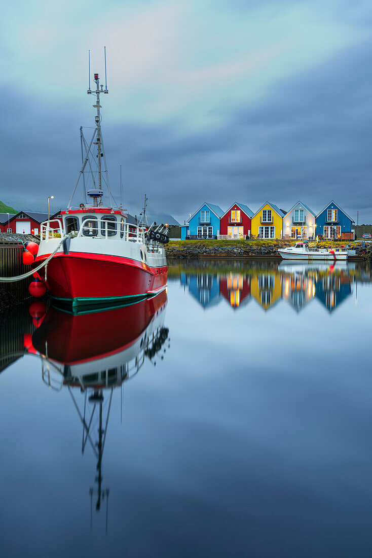 Bunte und beleuchtete Häuschen mit Spiegelung im Wasser des Hafens von Leirvik, Insel Eysturoy, Färöer Inseln, Dänemark, Europa
