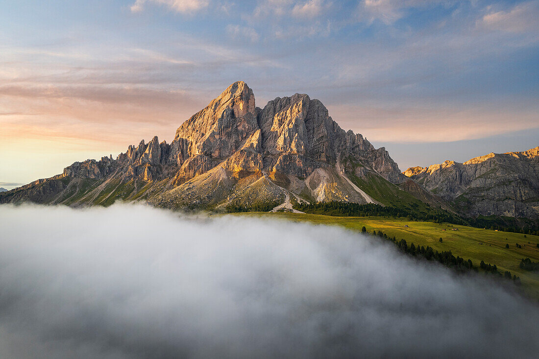 Luftaufnahme des Sass de Putia Massivs zwischen Wolken bei Sonnenaufgang, Passo delle Erbe, Dolomiten, Geislergruppe, Bozen, Südtirol, Italien, Europa.