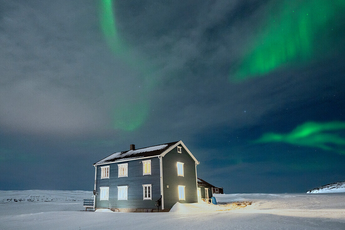 Einsames Haus im Schnee beleuchtet von Aurora Borealis, Veines, Kongsfjord, Varanger Halbinsel, Troms og Finnmark, Norwegen