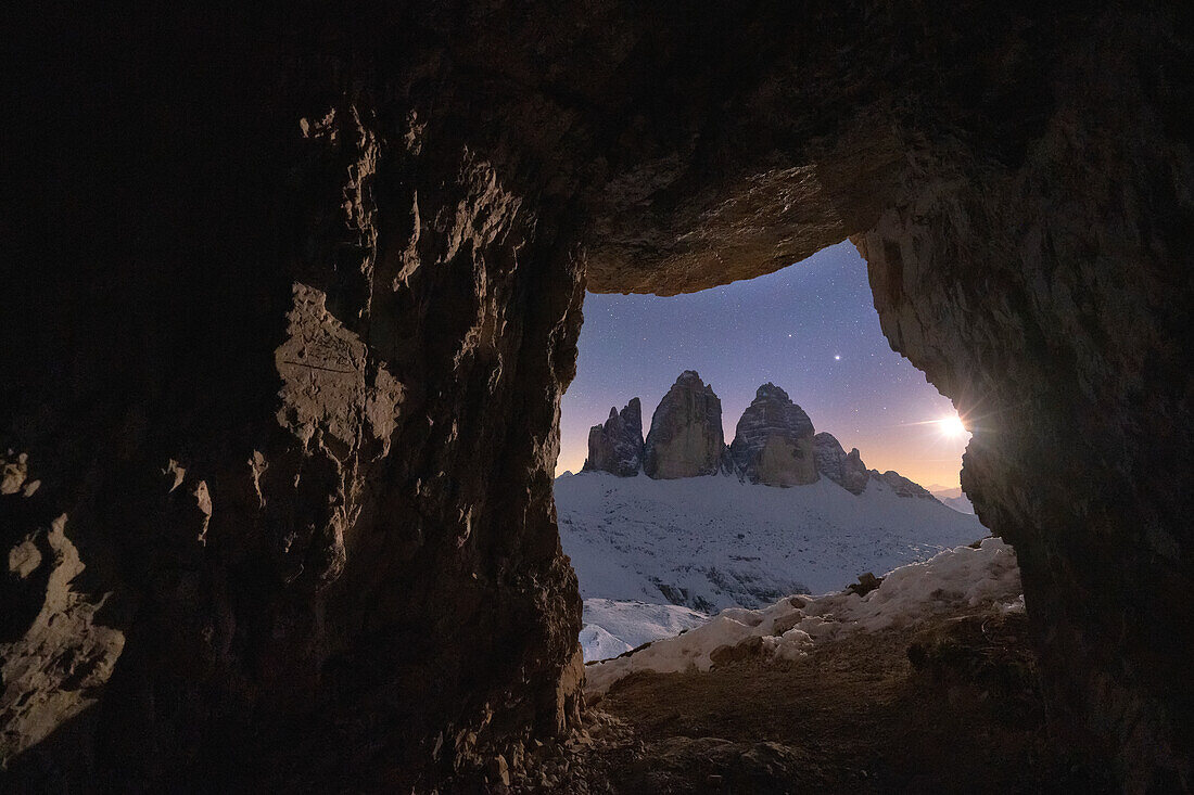 Vom Mond beleuchtete Drei Zinnen von einer Felsöffnung in einer Kriegshöhle aus gesehen, Sextner Dolomiten, Trentino-Südtirol, Italien