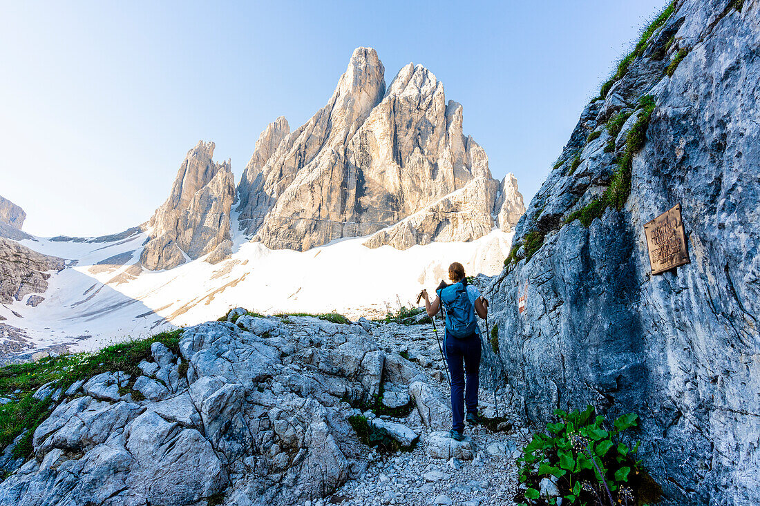 Hiker woman on mountain path from Rifugio Zsigmondy Comici to Pian di Cengia hut, Sesto Dolomites, South Tyrol, Italy