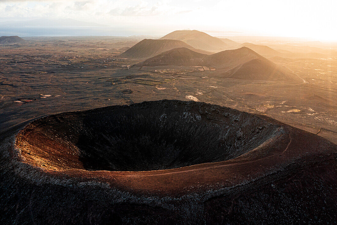 Luftaufnahme des Sonnenaufgangs über dem Krater des Vulkans Hondo (Calderon Hondo), Corralejo, Fuerteventura, Kanarische Inseln, Spanien