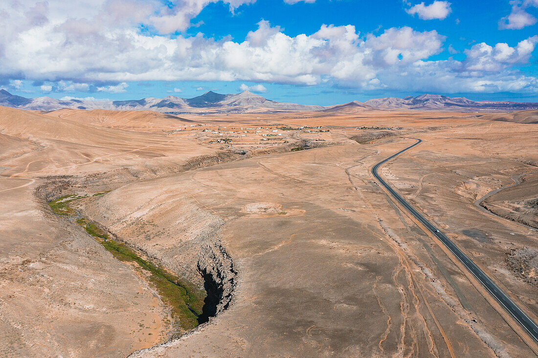 Luftaufnahme einer asphaltierten Straße durch die kargen Berge, Tefia, Fuerteventura, Kanarische Inseln, Spanien