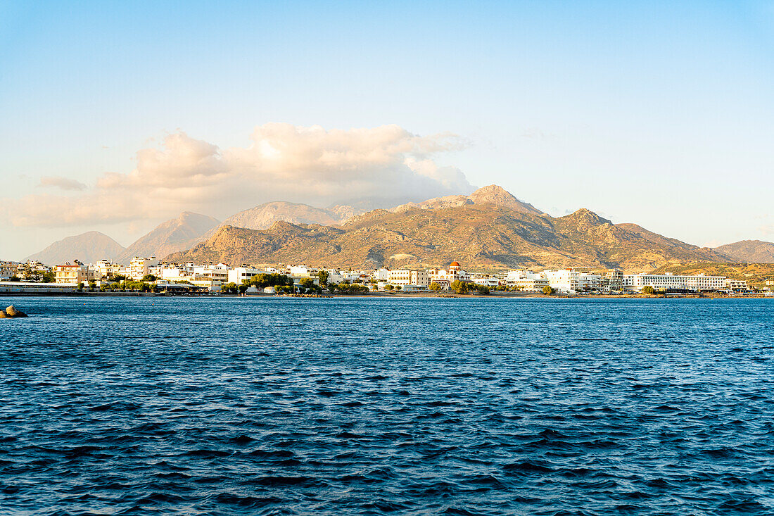 Coastal village of Ierapetra and mountains at sunset view from boat tour, Crete island, Greece