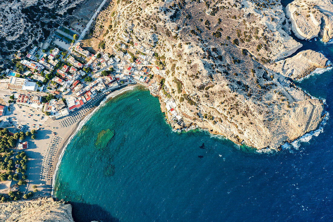 Luftaufnahme der majestätischen Klippen, die den Sandstrand der Stadt Matala am Meer umgeben, Kreta, Griechenland