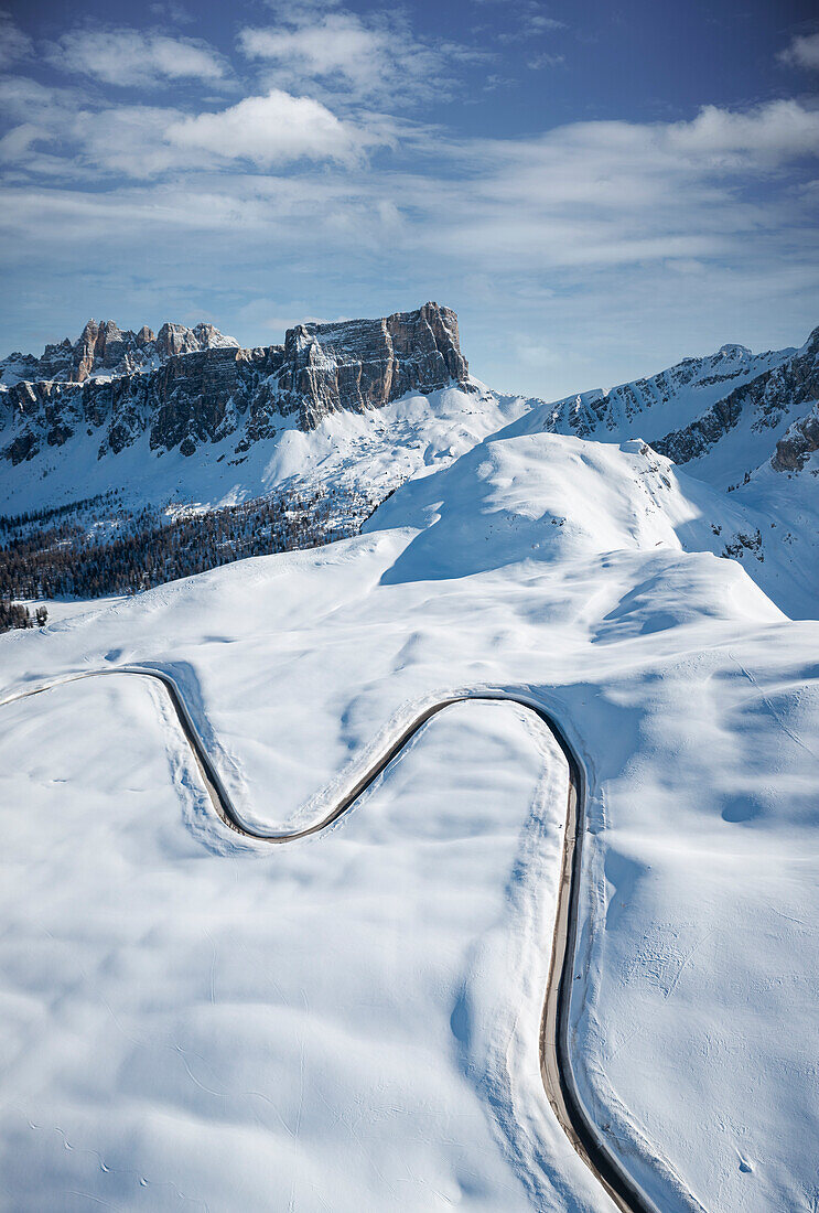 S-förmige Straße über die schneebedeckten Berge im Winter, Luftaufnahme, Giau-Pass, Dolomiten, Provinz Belluno, Venetien, Italien