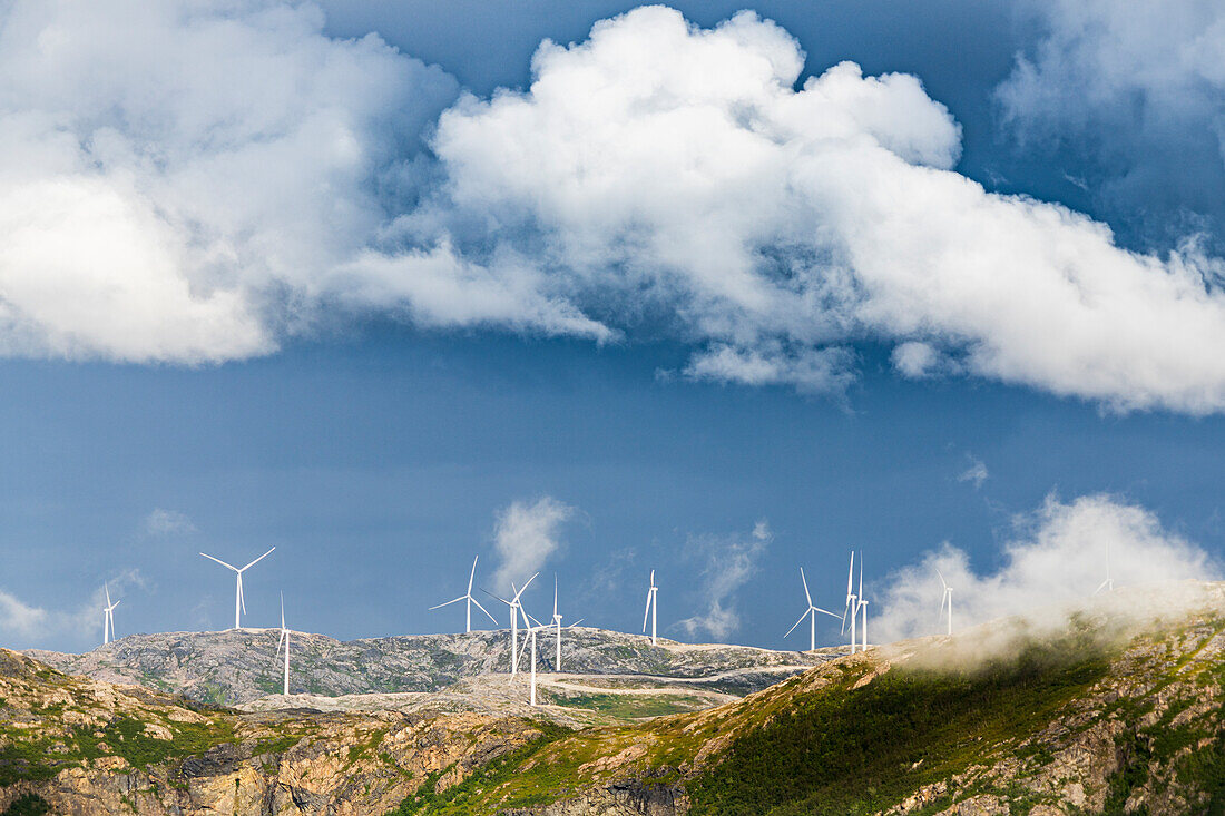 Wolken über Windkraftanlagen entlang des Fjords, Provinz Troms, Norwegen