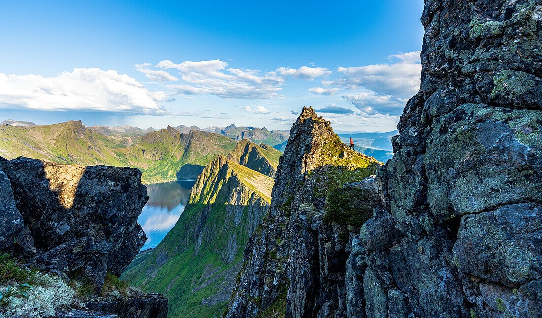 Person klettert auf Felsen am Husfjellet, Insel Senja, Provinz Troms, Norwegen