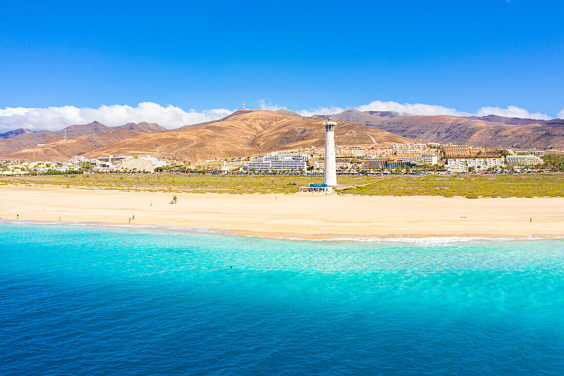 Türkisfarbenes Wasser des Ozeans um den Sandstrand und den Leuchtturm von Morro Jable, Fuerteventura, Kanarische Inseln, Spanien