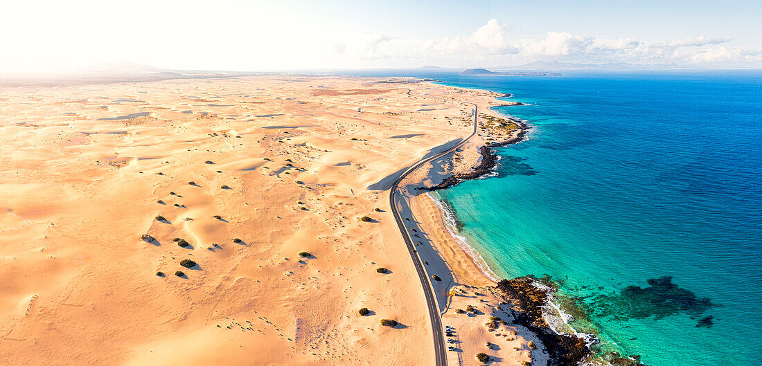 Luftaufnahme einer Panoramastraße, die an den Sanddünen des Naturparks Corralejo entlangführt, Fuerteventura, Kanarische Inseln, Spanien