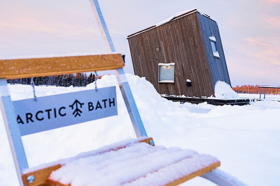Wooden cabin room of the Arctic bath hotel floating on the frozen river Lule covered with snow, Harads, Lapland, Sweden