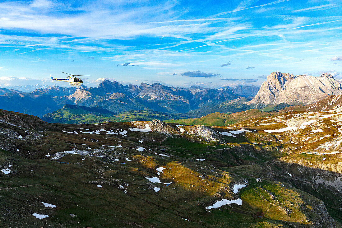 Helicopter flying towards Sciliar massif, Sassopiatto and Sassolungo, aerial view, Dolomites, South Tyrol, Italy