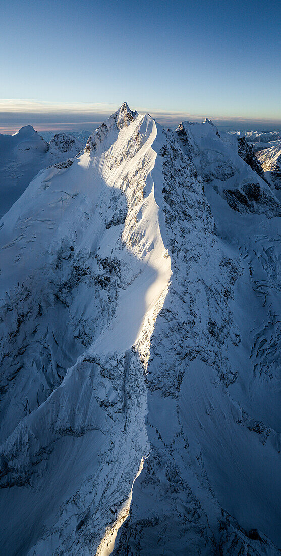 Aerial view of the snowcapped Piz Bernina and Biancograt mountain ridge at dawn, Graubunden canton, Engadine, Switzerland
