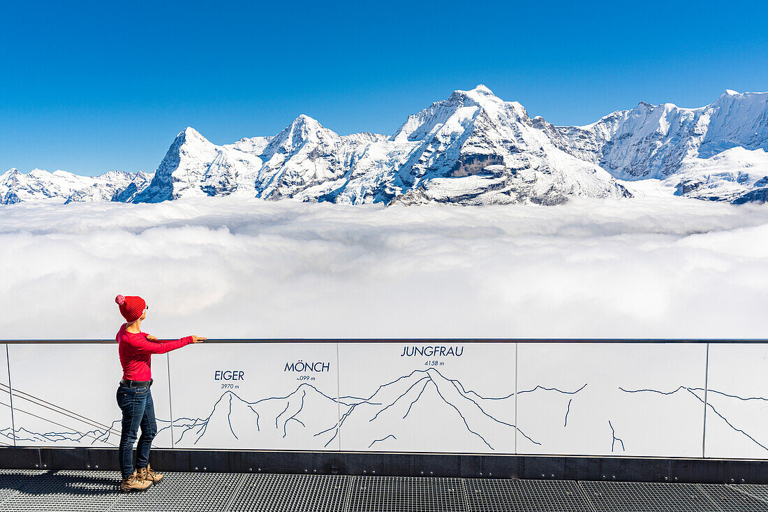 Frau bewundert die Berge Eiger, Mönch und Jungfrau im Nebel vom Panoramaweg aus, Murren Birg, Bern, Schweiz