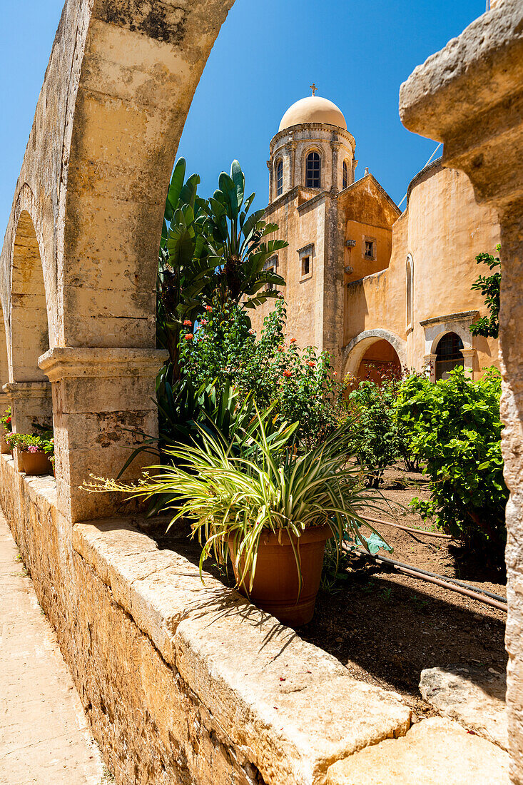 Alter Gewölbebogen mit dem mittelalterlichen Komplex des Klosters Agia Triada Tzagarolon im Hintergrund, Kreta, Griechenland