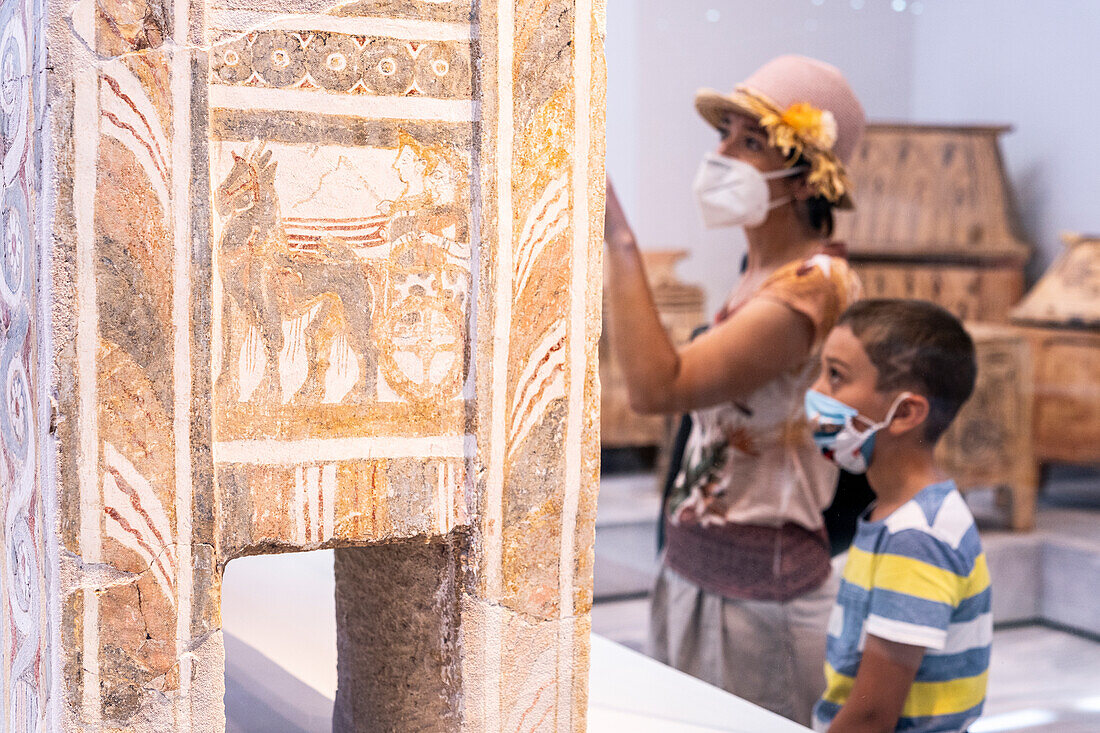 Mutter und kleiner Junge mit Gesichtsmasken betrachten den alten Sarkophag, Archäologisches Museum Heraklion, Insel Kreta, Griechenland