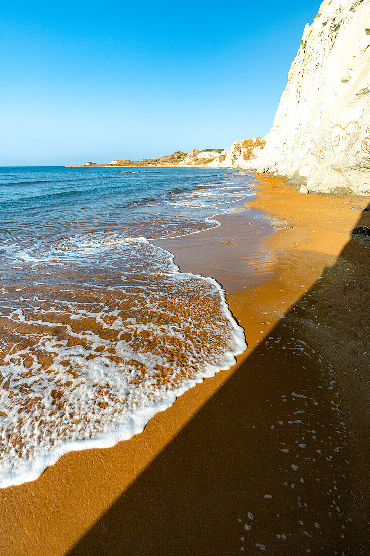 Sunrise over the tall cliffs above Xi beach washed by waves, Kefalonia, Ionian Islands, Greece